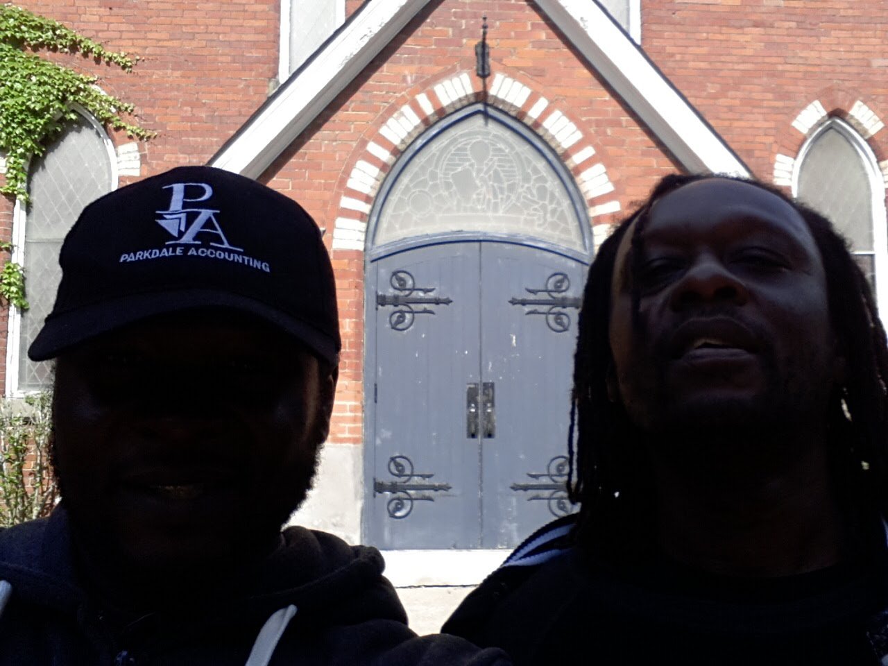 Trav with his dad in front of a brick church